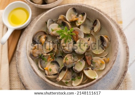 Cockles cooked in green sauce. Traditional Basque country recipe. Spanish cover. Royalty-Free Stock Photo #2148111617
