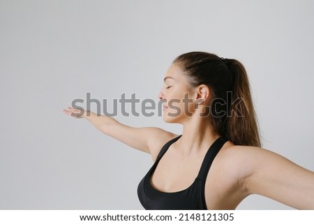 Portrait of sporty young woman doing yoga practice isolated on white wall.