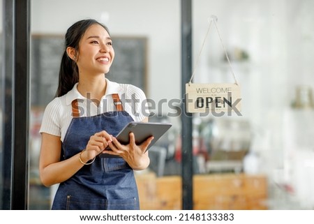 Startup successful small business owner sme beauty girl stand with tablet smartphone in coffee shop restaurant. Portrait of asian tan woman barista cafe owner. SME entrepreneur seller business concept Royalty-Free Stock Photo #2148133383