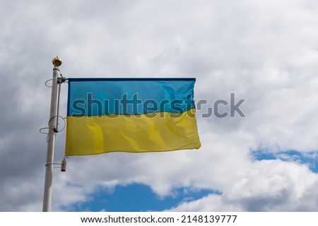Ukrainian banner wave on the background of cloudy, dramatic sky. Picture taken in the day, sky full of clouds.  
