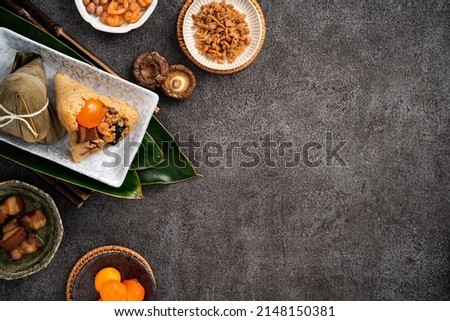 Zongzi. Rice dumpling for Chinese traditional Dragon Boat Festival (Duanwu Festival) on dark gray table background with ingredient.