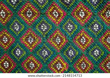 Handmade multicolor carpet with rhombus ornament, braided mat, closeup, texture background. Royalty-Free Stock Photo #2148154713