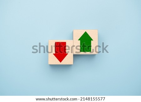 Rising and falling trends. green up arrow in bright side and red down arrow in dark side which print screen on wooden cube block for economic and business profit growth concept. copy space Royalty-Free Stock Photo #2148155577