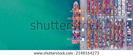 Aerial top view over international containers cargo ship at industrial import-export port prepare to load containers with big container loader ship vessel. global transportation and logistic business. Royalty-Free Stock Photo #2148164273