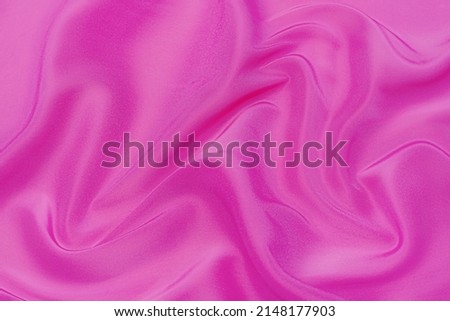 Close-up texture of natural red or pink fabric or cloth in same color. Fabric texture of natural cotton, silk or wool, or linen textile material. Red and orange canvas background. Royalty-Free Stock Photo #2148177903