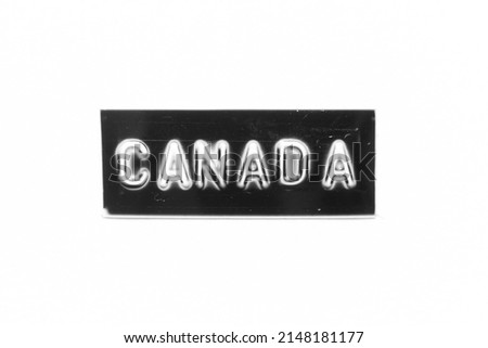 Black color banner that have embossed letter with word canada on white paper background