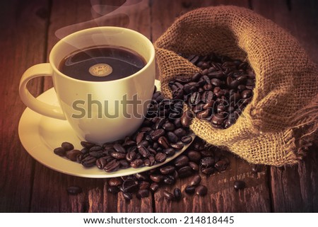 coffee cup and jute sack close-up on wooden table background