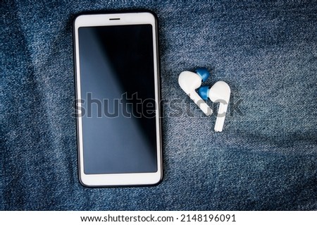 Smartphone and earphone  on blue shabby jeans hipster modern life style layout for inserting text