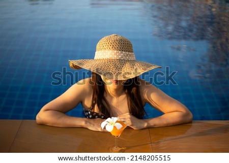 Women relaxing near luxury swimming pool