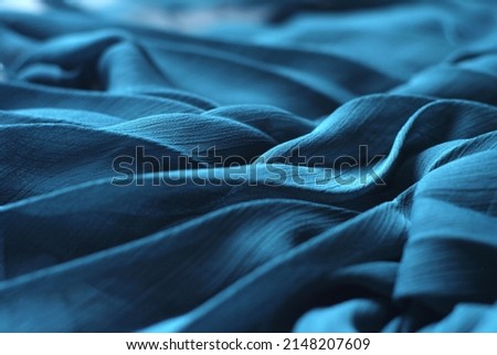 Delicate background texture: elegant soft blue silk fabric. Tissue clothing, luxurious dress textile with folds. Chiffon cloth, 3d abstract sea waves with cyan color Royalty-Free Stock Photo #2148207609