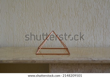 
Copper pyramid. Vazada em travertino marble table with alvenaria branca wall, Brazil, South America, graffito style wall, lateral photo Royalty-Free Stock Photo #2148209501