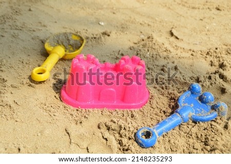 Plastics sand toys for kids on the beach. Sand castle plastic toy, rake and shovel plastic toys for kids.  Royalty-Free Stock Photo #2148235293