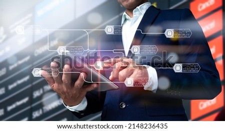 A chain diagram and encrypted blocks are used to demonstrate the blockchain technology idea. A businessman's hand holding a digital tablet, as well as a business plan and social media diagram. Royalty-Free Stock Photo #2148236435