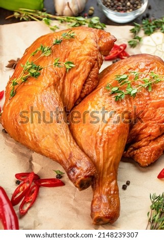 Smoked chicken legs on parchment with spices, close-up. Culinary background for recipes. Cooking food. Food background. Copy space. Table background menu.