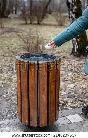 female hand throws a crumpled bag into the trash. High quality photo
