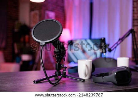 No people at empty desk with recording equipment to broadcast live conversation on social media. Nobody in space with podcast station, microphone and headphones, sound production. Royalty-Free Stock Photo #2148239787