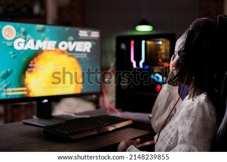 Frustrated streamer losing action video games competition play, using pc to stream gaming tournament. Female gamer feeling sad about lost online rpg multiplayer gameplay championship. Royalty-Free Stock Photo #2148239855
