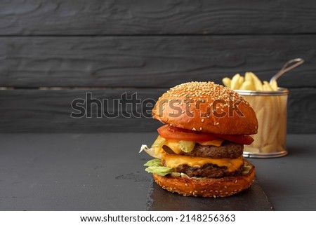 Tasty burger on black wooden background close up