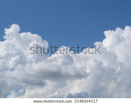 A big white fluffy cloud in the blue sky. the sky with a large cloud is lonely for the background. A Big White Cloud In The Sky In Summer Royalty-Free Stock Photo #2148264517