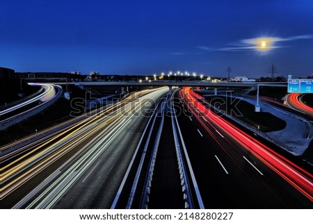 Freeway traffic on German roads at night - light trays during sun set and blue hour Royalty-Free Stock Photo #2148280227