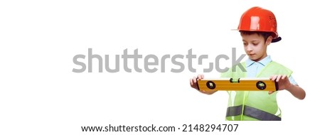 building, construction and profession concept - little caucasian boy in protective helmet and safety vest with level over white background