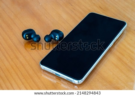 Cell phone with wireless headphones.