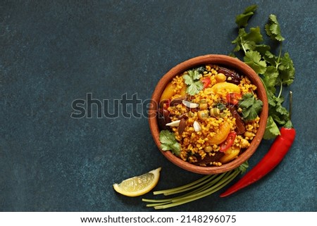 Vegan Moroccan Couscous with Chick Peas, spinach, dried apricots and date fruit. Traditional African Tajine dish. Flat layot