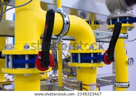 The gas pipeline is yellow with additional equipment, pipes and a valve to shut off the gas supply.