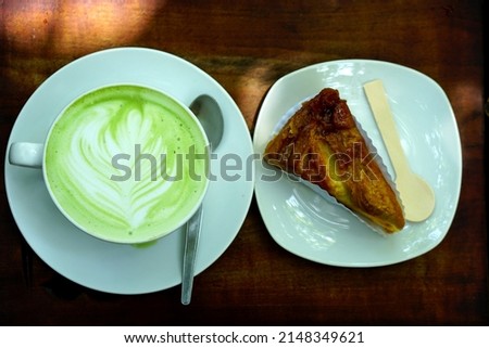 hot green tea and banana cake on wooden floor	                   