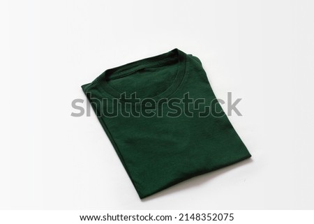Close up shot of folded dark green t-shirt with white background