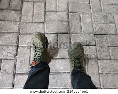 army green boots on paving blocks