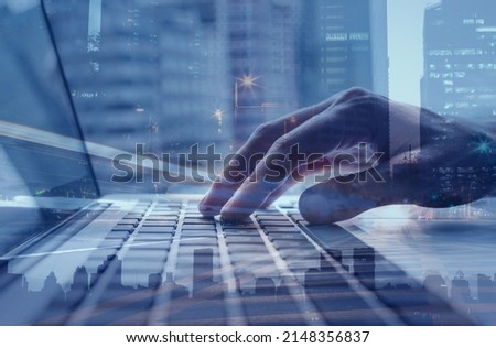 Double exposure business man working on laptop computer, in the cityscape. Modern technology, smart business , cloud computing concept