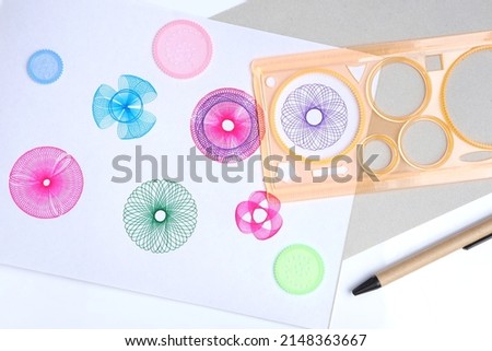 Spirograph ruler on white background. Drawing the spirograph pattern on white paper. drawing the spirograph pattern with spirograph kit.