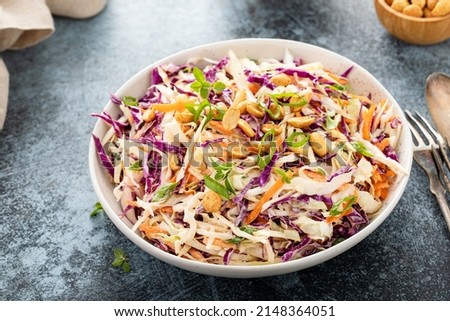 Asian cabbage cole slaw with peanut sauce, roasted peanuts and green onions Royalty-Free Stock Photo #2148364051