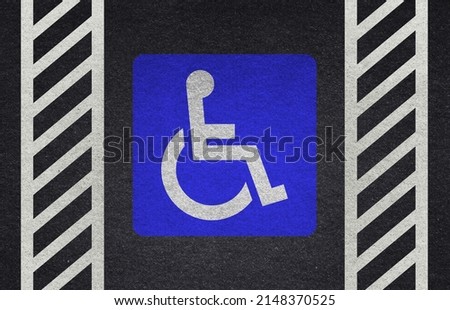 wheelchair sign on the pavement. Wheelchair Handicap Sign on dark asphalt road street background- handicap parking place