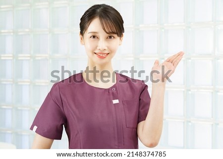 A woman in a beauty treatment salon or clinic uniform who poses as a guide Royalty-Free Stock Photo #2148374785