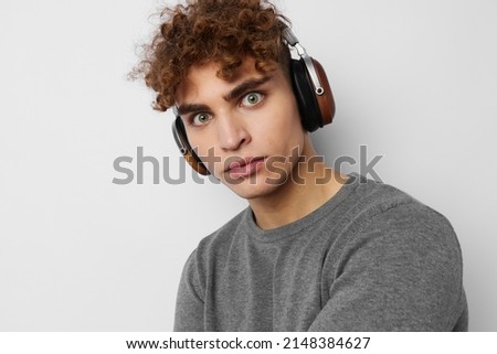 stylish guy listening to music in headphones emotions light background