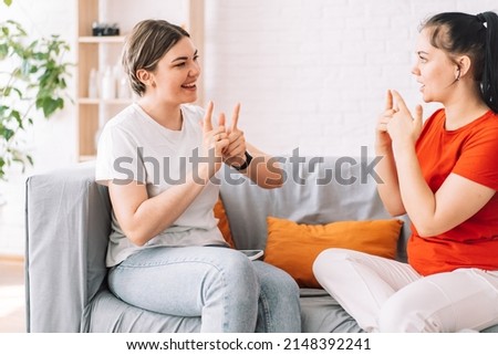 Two girls talking in sign language.