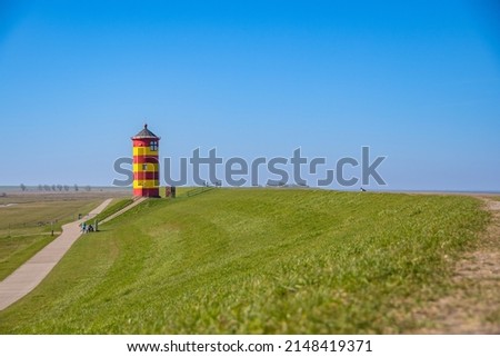 
The yellow red lighthouse of Pilsum on a sunny day Royalty-Free Stock Photo #2148419371