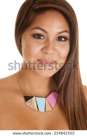 A woman with a smile on her face, wearing a necklace with different colors and shapes.
