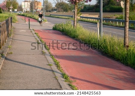 bicycle lane close to the road, with a dedicated red path for athletes with two wheels or on foot such as runners.