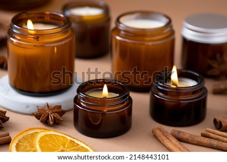 A set of different aroma candles in brown glass jars. Scented handmade candle. Soy candles are burning in a jar. Aromatherapy and relax in spa and home. Royalty-Free Stock Photo #2148443101