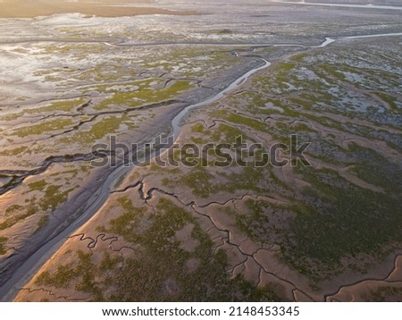 Aerial drone. Salt marshes at low tide exposing mud flats and streams at Motney Hill, Medway, Kent, England. Royalty-Free Stock Photo #2148453345