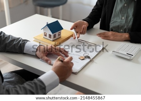 Real estate agent holding house key to his client after signing contract,concept for real estate, moving home or renting property