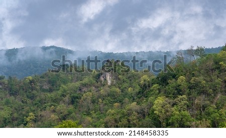 Scenic rural landscape with limestone mountain and tropical forest under low clouds in beautiful countryside valley, Chiang Dao, Chiang Mai, Thailand