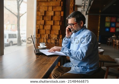 man using laptop in cafe bar.