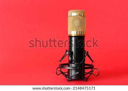 Stand with modern microphone on red background