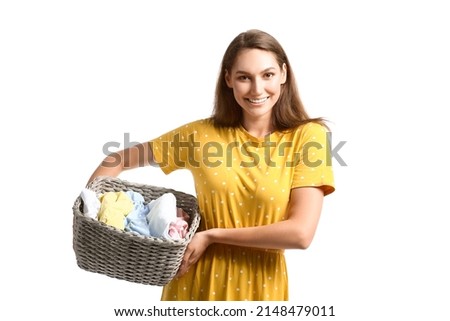 Beautiful housewife holding wicker basket with laundry on white background Royalty-Free Stock Photo #2148479011