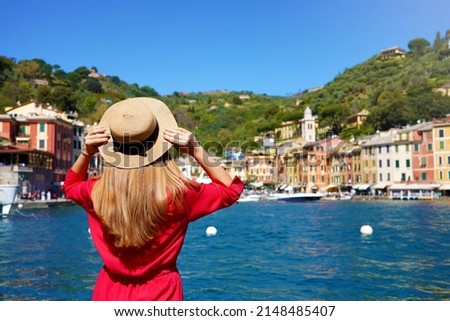 Visiting Portofino, Italy. Travel tourist girl on vacation enjoying view of Portofino harbour. Attractive young romantic woman enjoying view of Portofino picturesque village in Italy. Royalty-Free Stock Photo #2148485407