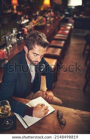 It all starts with a plot. High angle shot of a young man sitting with his journal in a bar. Royalty-Free Stock Photo #2148498819